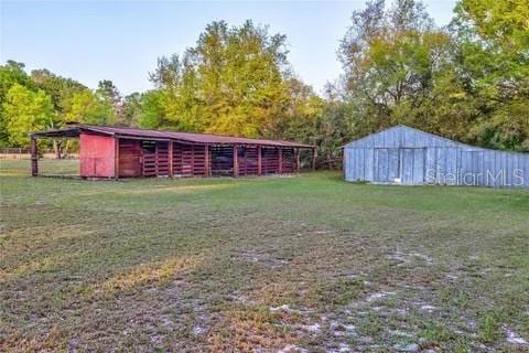 view of grassy yard with a pole building and an outdoor structure