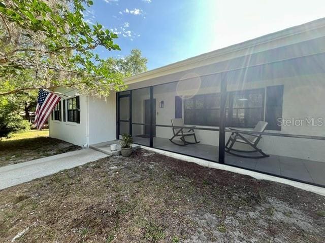rear view of house featuring a sunroom
