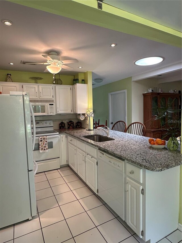 66 Elmwood Trl, Deland, FL 32724 - kitchen featuring white appliances, a sink, a peninsula, white cabinetry, and recessed lighting
