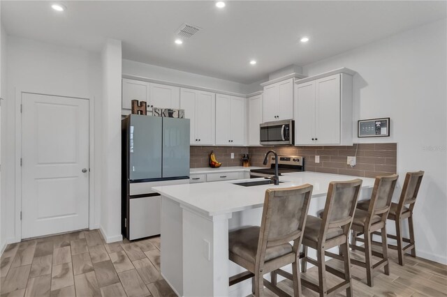 2552 Chickasaw Plum Loop, Clermont, FL 34711 - kitchen with stainless steel appliances, a peninsula, a sink, a kitchen bar, and light countertops