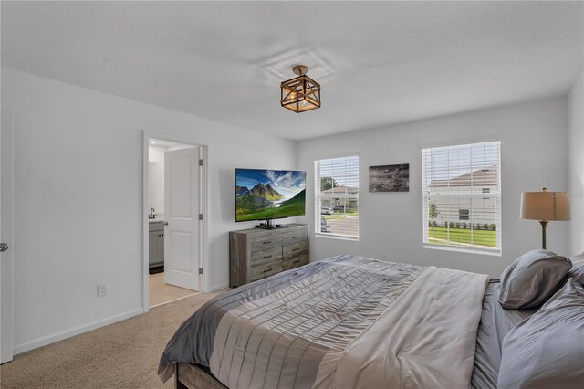 2552 Chickasaw Plum Loop, Clermont, FL 34711 - bedroom with light colored carpet, baseboards, and ensuite bath