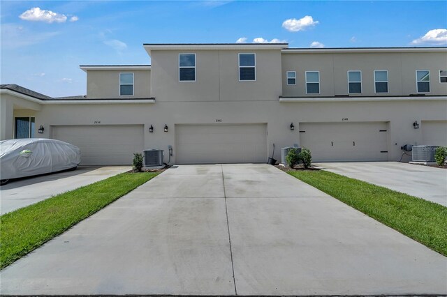2552 Chickasaw Plum Loop, Clermont, FL 34711 - view of front facade featuring stucco siding, an attached garage, and cooling unit