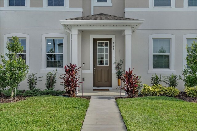 2552 Chickasaw Plum Loop, Clermont, FL 34711 - doorway to property with stucco siding and a lawn