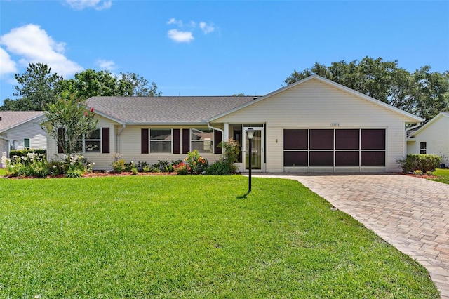 26608 Racquet Cir, Leesburg, FL 34748 - single story home with an attached garage, decorative driveway, a front lawn, and a sunroom