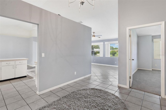 26608 Racquet Cir, Leesburg, FL 34748 - empty room featuring light tile patterned flooring, baseboards, ceiling fan, and light carpet