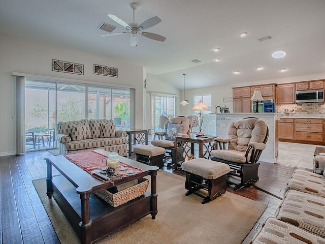 3136 Vandenberg Ct, The Villages, FL 32163 - living area with light wood-style flooring, vaulted ceiling, ceiling fan, and baseboards