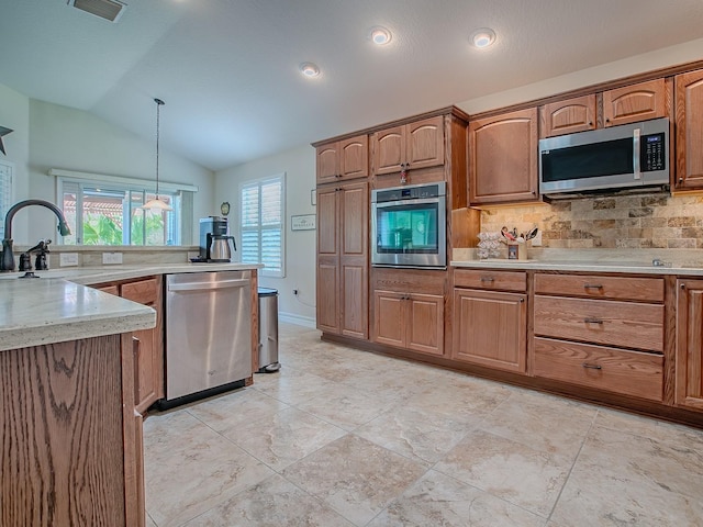 3136 Vandenberg Ct, The Villages, FL 32163 - kitchen with stainless steel appliances, a sink, vaulted ceiling, tasteful backsplash, and decorative light fixtures
