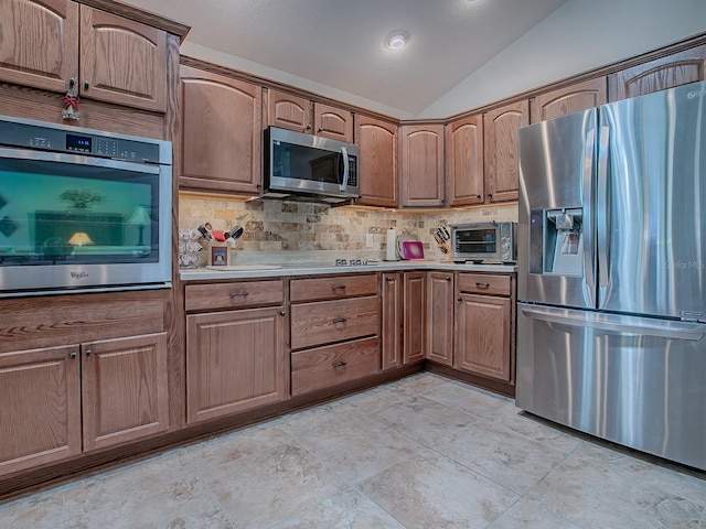 3136 Vandenberg Ct, The Villages, FL 32163 - kitchen with appliances with stainless steel finishes, lofted ceiling, decorative backsplash, and light countertops
