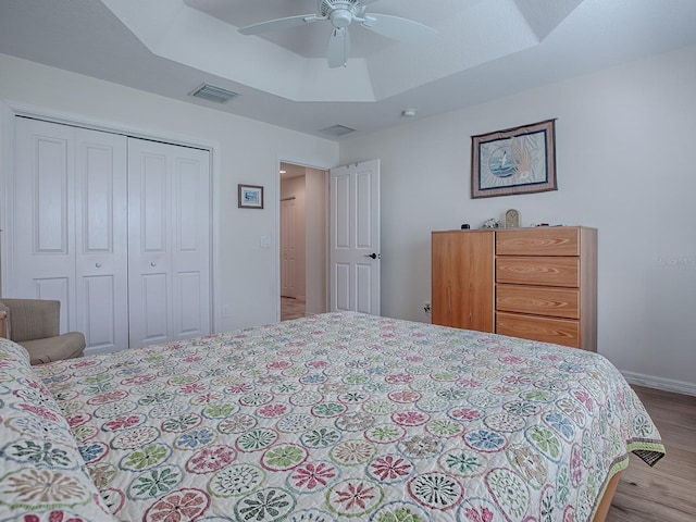 3136 Vandenberg Ct, The Villages, FL 32163 - bedroom with wood finished floors, a closet, ceiling fan, baseboards, and a tray ceiling