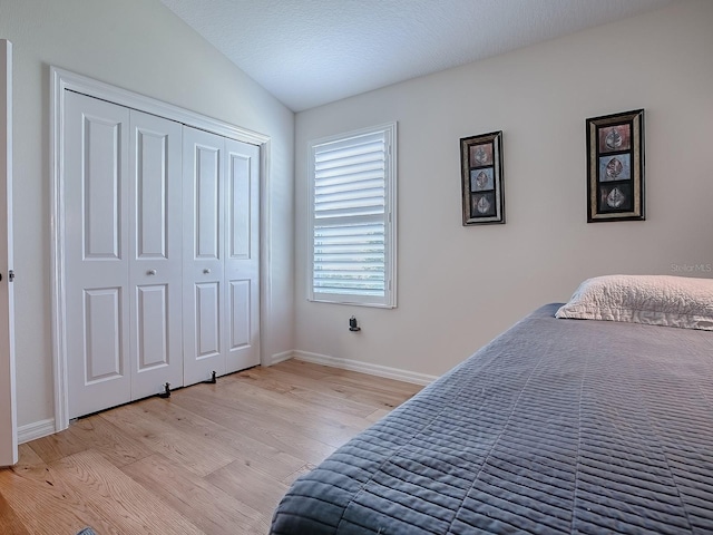 3136 Vandenberg Ct, The Villages, FL 32163 - bedroom with light wood-type flooring, baseboards, lofted ceiling, and a closet