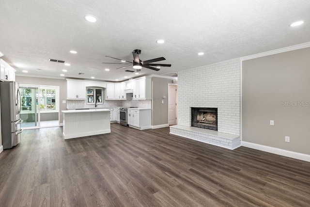 unfurnished living room with ornamental molding, recessed lighting, a ceiling fan, dark wood-style floors, and a fireplace