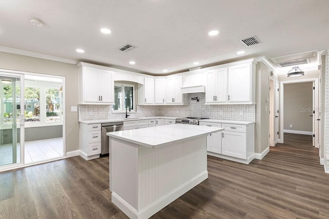 kitchen featuring stainless steel appliances, ornamental molding, dark wood-type flooring, white cabinets, and recessed lighting