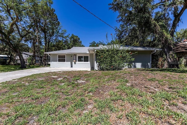 ranch-style home featuring concrete driveway and stucco siding