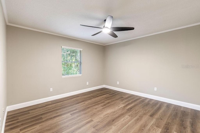 unfurnished room with dark wood-style floors, a ceiling fan, baseboards, ornamental molding, and a textured ceiling