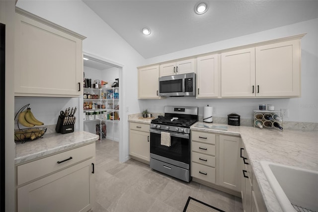 4451 Elijah Loop, The Villages, FL 32163 - kitchen with stainless steel appliances, vaulted ceiling, a sink, light stone counters, and recessed lighting