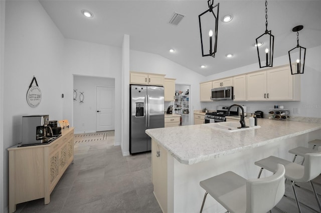 4451 Elijah Loop, The Villages, FL 32163 - kitchen with appliances with stainless steel finishes, a sink, a peninsula, lofted ceiling, and a kitchen bar