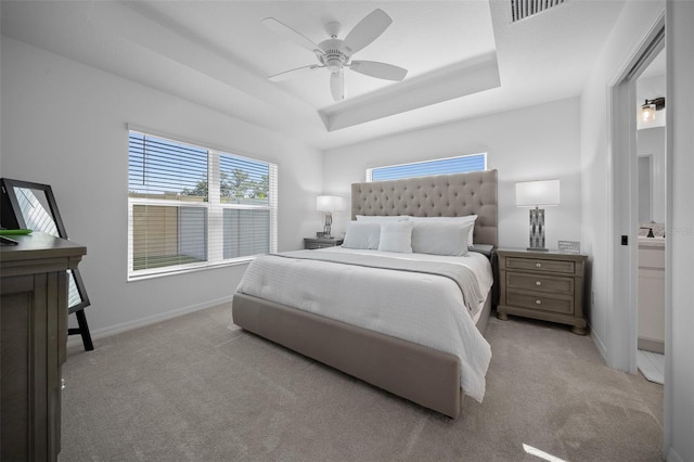 4451 Elijah Loop, The Villages, FL 32163 - bedroom featuring light carpet, baseboards, a tray ceiling, and a ceiling fan