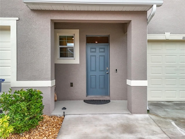 1042 Lido Dr, Howey In The Hills, FL 34737 - view of exterior entry with stucco siding and a garage