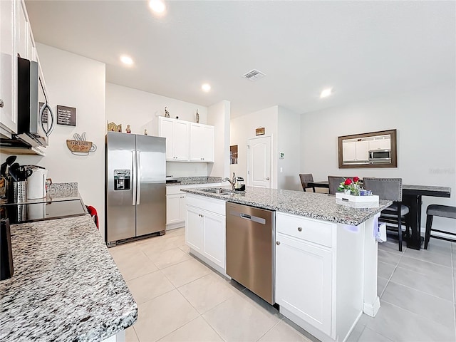 1042 Lido Dr, Howey In The Hills, FL 34737 - kitchen featuring stainless steel appliances, a sink, white cabinets, light tile patterned floors, and recessed lighting