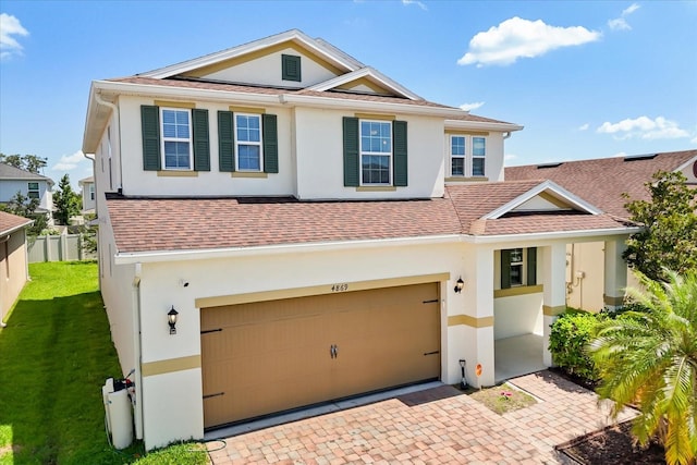 4869 Grassendale Ter, Sanford, FL 32771 - view of front facade featuring stucco siding, a garage, roof with shingles, and decorative driveway