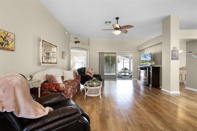 815 Cortez Ave, The Villages, FL 32159 - living area featuring wood finished floors, ceiling fan, a glass covered fireplace, and a textured ceiling