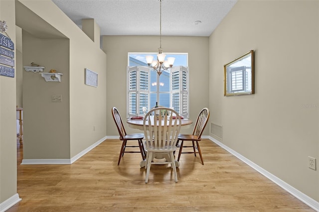 815 Cortez Ave, The Villages, FL 32159 - dining area featuring light wood finished floors, a chandelier, and a textured ceiling