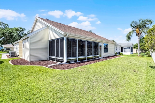 815 Cortez Ave, The Villages, FL 32159 - rear view of house featuring a sunroom, a yard, and roof with shingles