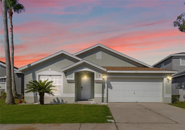ranch-style home featuring stucco siding, concrete driveway, a lawn, and a garage
