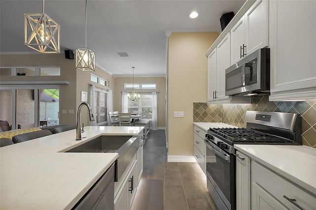 6243 Danielson Loop, The Villages, FL 32163 - kitchen with appliances with stainless steel finishes, baseboards, backsplash, white cabinetry, and dark tile patterned floors