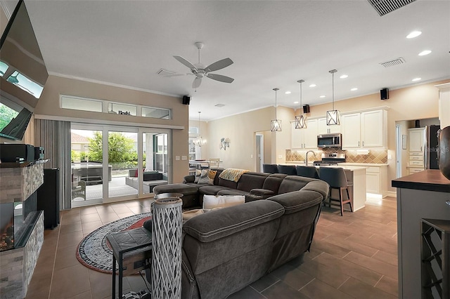6243 Danielson Loop, The Villages, FL 32163 - living room with a ceiling fan, recessed lighting, ornamental molding, a fireplace, and tile patterned flooring
