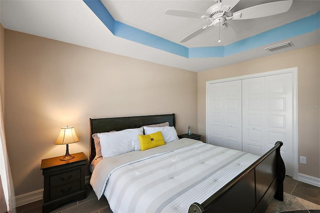 6243 Danielson Loop, The Villages, FL 32163 - bedroom featuring a closet, a raised ceiling, baseboards, and dark tile patterned flooring