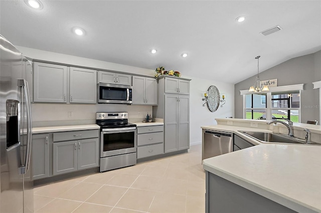 11287 Stewart Loop, Oxford, FL 34484 - kitchen with stainless steel appliances, gray cabinets, a sink, lofted ceiling, and decorative light fixtures