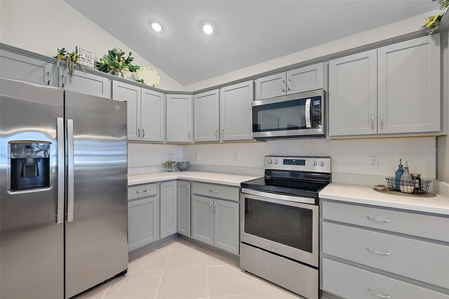 11287 Stewart Loop, Oxford, FL 34484 - kitchen featuring appliances with stainless steel finishes, gray cabinets, lofted ceiling, light countertops, and light tile patterned flooring