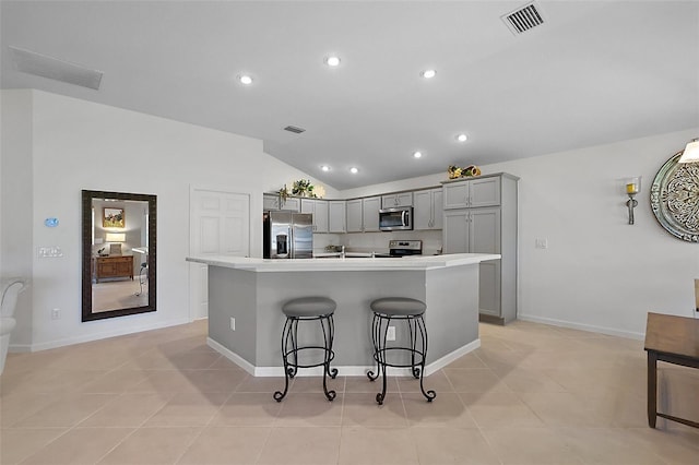 11287 Stewart Loop, Oxford, FL 34484 - kitchen with gray cabinets, stainless steel appliances, lofted ceiling, a kitchen breakfast bar, and light countertops