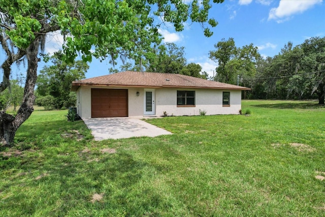 10655 N Party Ave, Dunnellon, FL 34433 - rear view of house with stucco siding, a garage, a lawn, and driveway