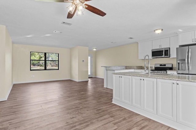 10655 N Party Ave, Dunnellon, FL 34433 - kitchen with stainless steel appliances, a ceiling fan, light wood-style floors, white cabinets, and a sink