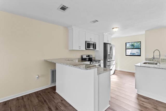 10655 N Party Ave, Dunnellon, FL 34433 - kitchen featuring appliances with stainless steel finishes, a sink, dark wood-style flooring, light stone counters, and baseboards