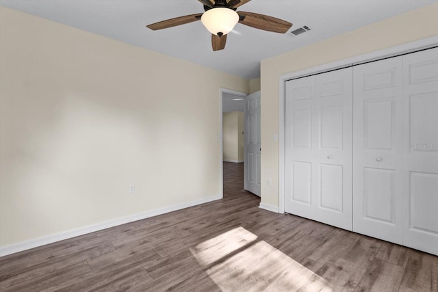 10655 N Party Ave, Dunnellon, FL 34433 - unfurnished bedroom featuring wood finished floors, baseboards, a closet, and ceiling fan