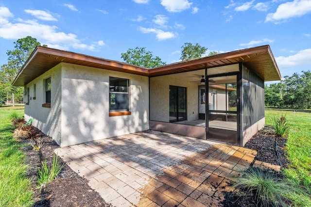 10655 N Party Ave, Dunnellon, FL 34433 - rear view of property with stucco siding, a patio area, a ceiling fan, and a sunroom