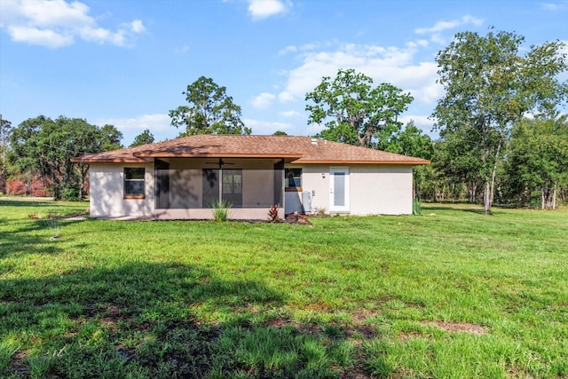 10655 N Party Ave, Dunnellon, FL 34433 - rear view of property with a sunroom, a ceiling fan, a lawn, and stucco siding