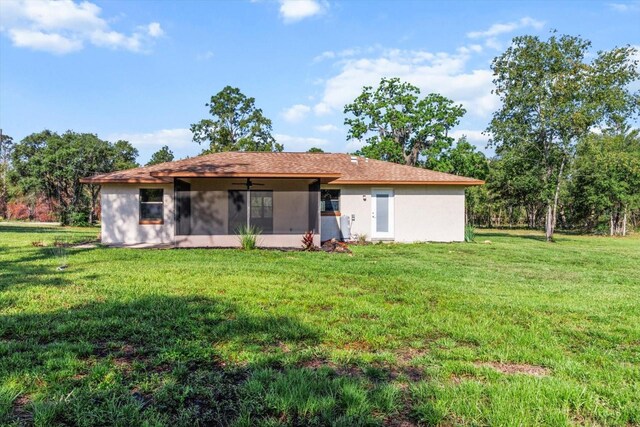 10655 N Party Ave, Dunnellon, FL 34433 - back of property with a sunroom, ceiling fan, a yard, and stucco siding