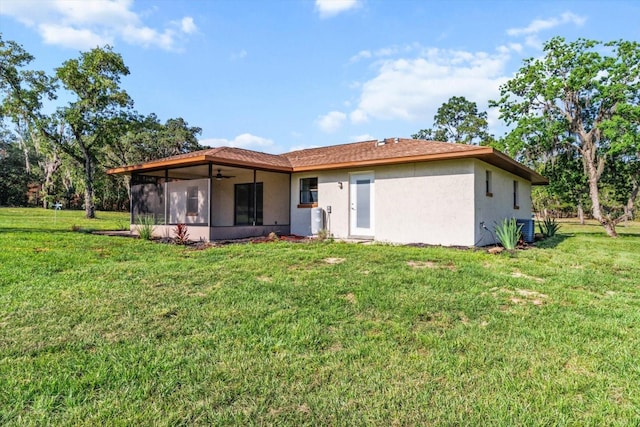 10655 N Party Ave, Dunnellon, FL 34433 - back of property with a sunroom, a ceiling fan, stucco siding, and a yard