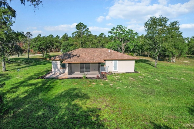 10655 N Party Ave, Dunnellon, FL 34433 - rear view of property with a sunroom, a lawn, and stucco siding