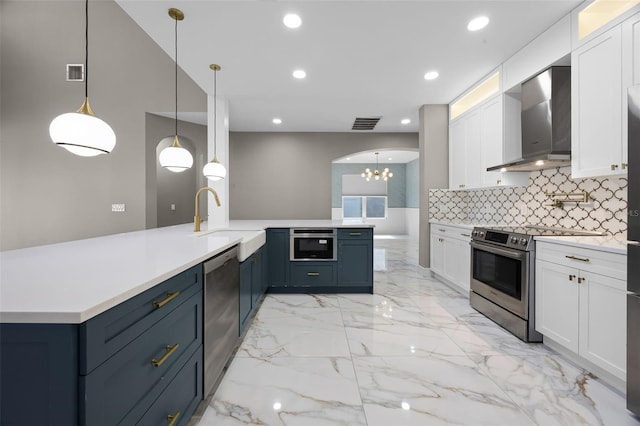 kitchen featuring wall chimney exhaust hood, appliances with stainless steel finishes, a sink, white cabinetry, and recessed lighting