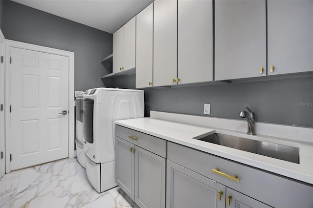 laundry room featuring light marble finish floors, cabinet space, and washer and clothes dryer