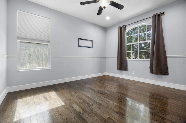 empty room with wood-type flooring, a ceiling fan, and baseboards