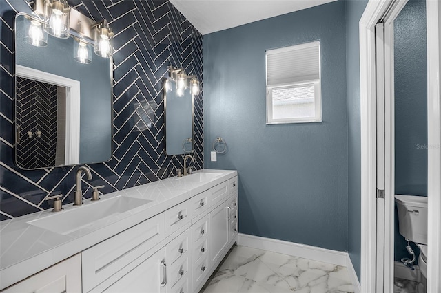 bathroom featuring toilet, baseboards, marble finish flooring, double vanity, and decorative backsplash