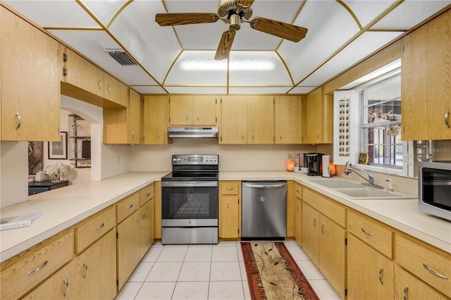 kitchen featuring appliances with stainless steel finishes, under cabinet range hood, a sink, a ceiling fan, and light countertops