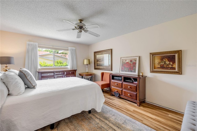 bedroom featuring light wood-style floors, radiator, a textured ceiling, and ceiling fan