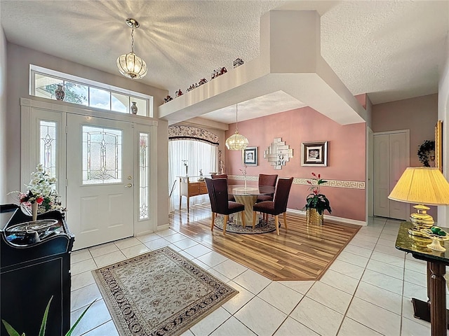 2415 Twickingham Ct, Clermont, FL 34711 - foyer entrance featuring a chandelier, a textured ceiling, light tile patterned floors, and baseboards